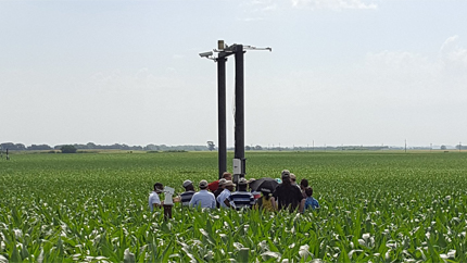 Group of people in field in front of equipment