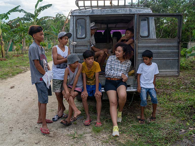 People together sitting on back of vehicle