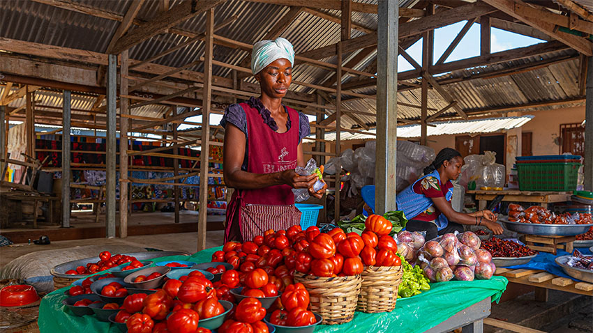 Person behind table with vegetables