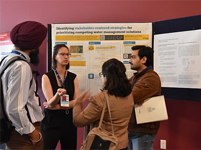 People having conversation in front of poster board