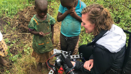 Person showing photography equipment to children