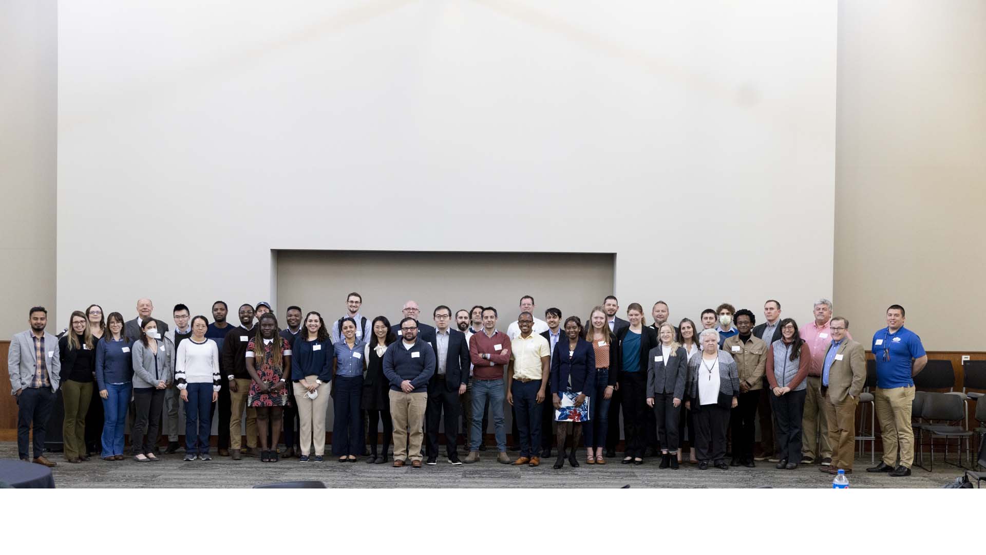 Large group standing in front of wall