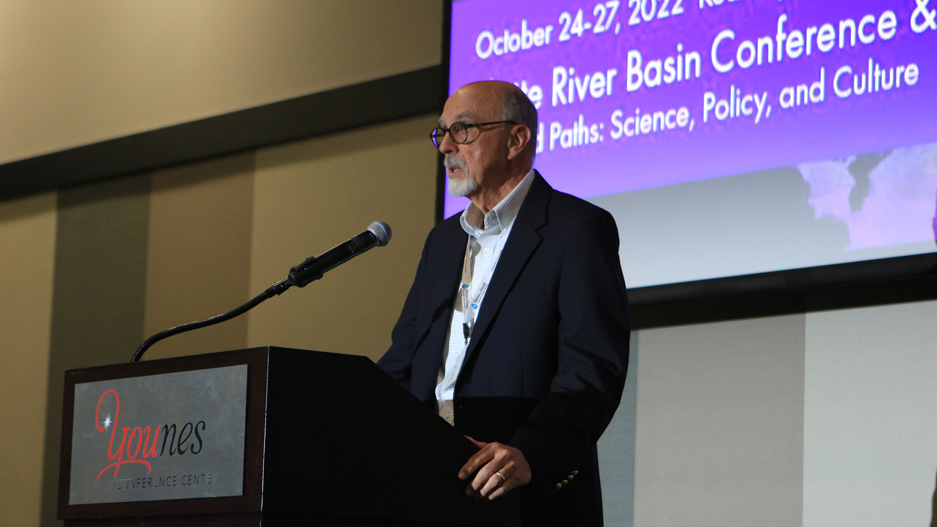 Person standing at podium in front of screen