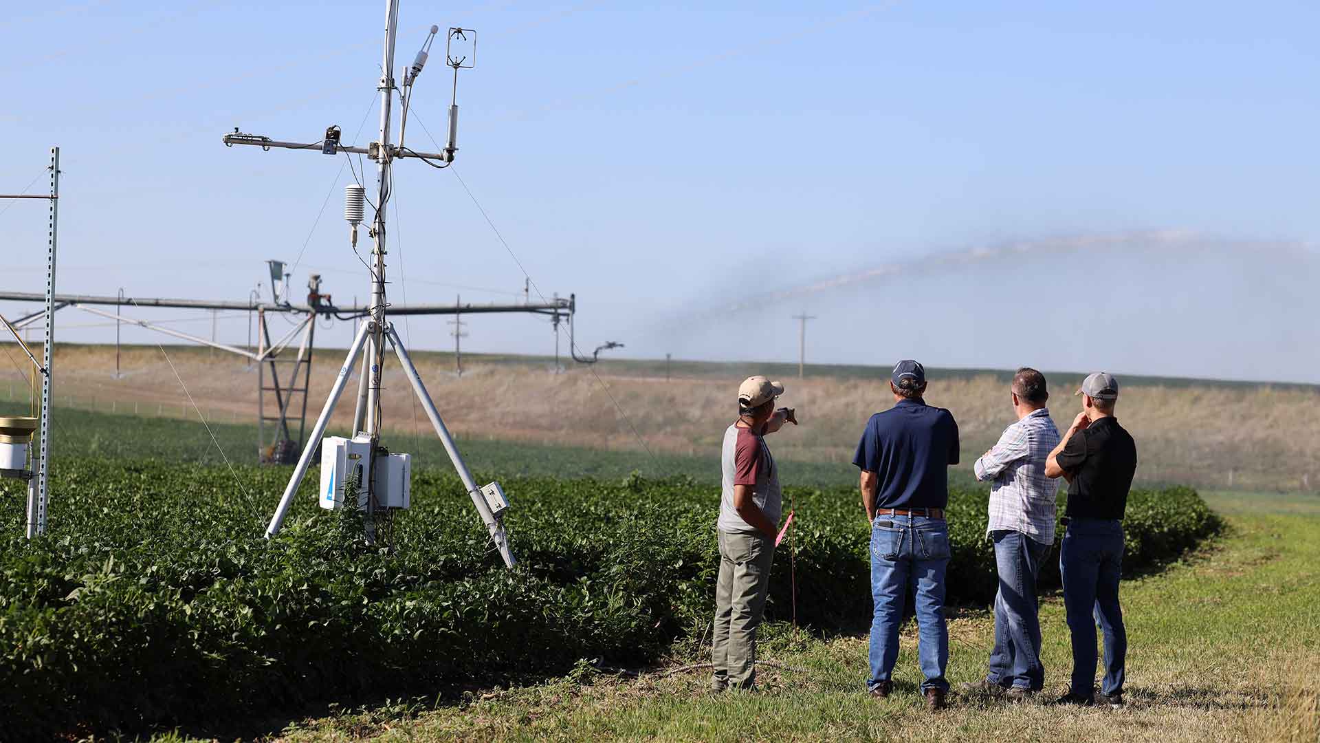 Small group beside equipment sitting in agriculture field