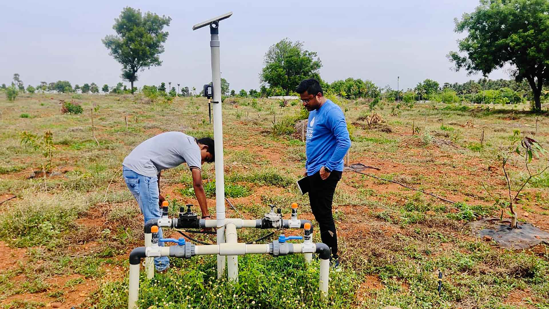 Two people working on irrigation valves
