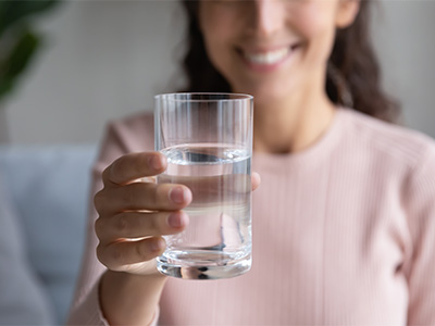 Person holding glass of water