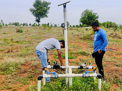 Two people working on irrigation valves