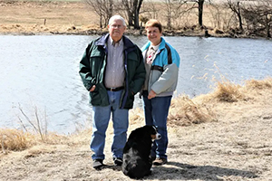Two people standing by lake