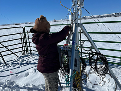 Person working on instruments in snow covered field