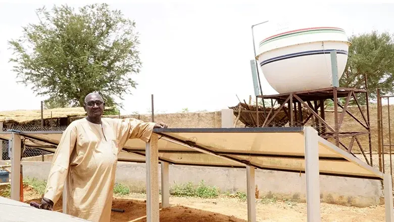 Person standing beside solar panel