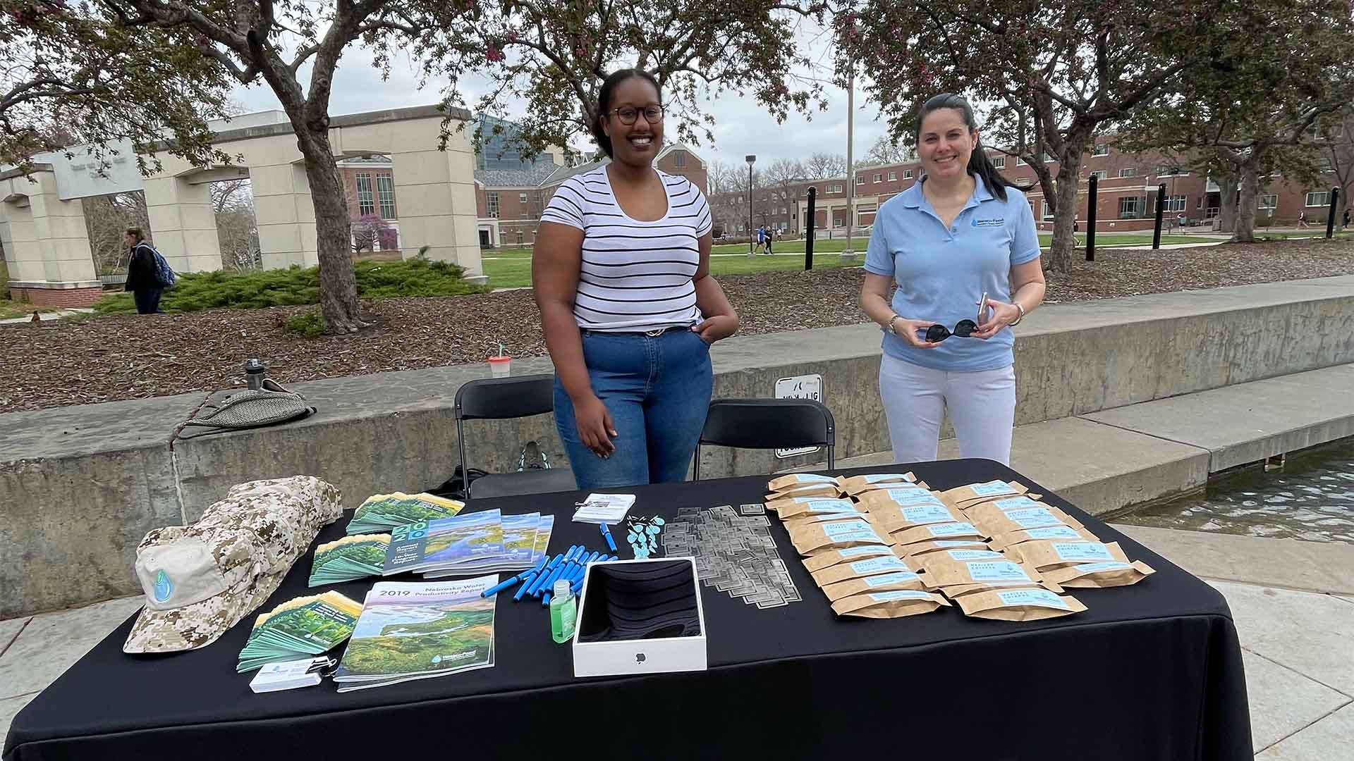 Two people standing outside in front of table