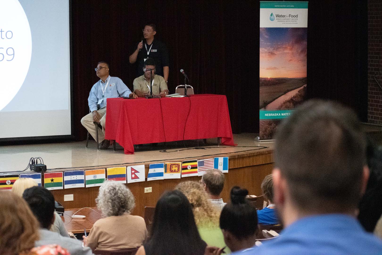 People sitting at table on a stage