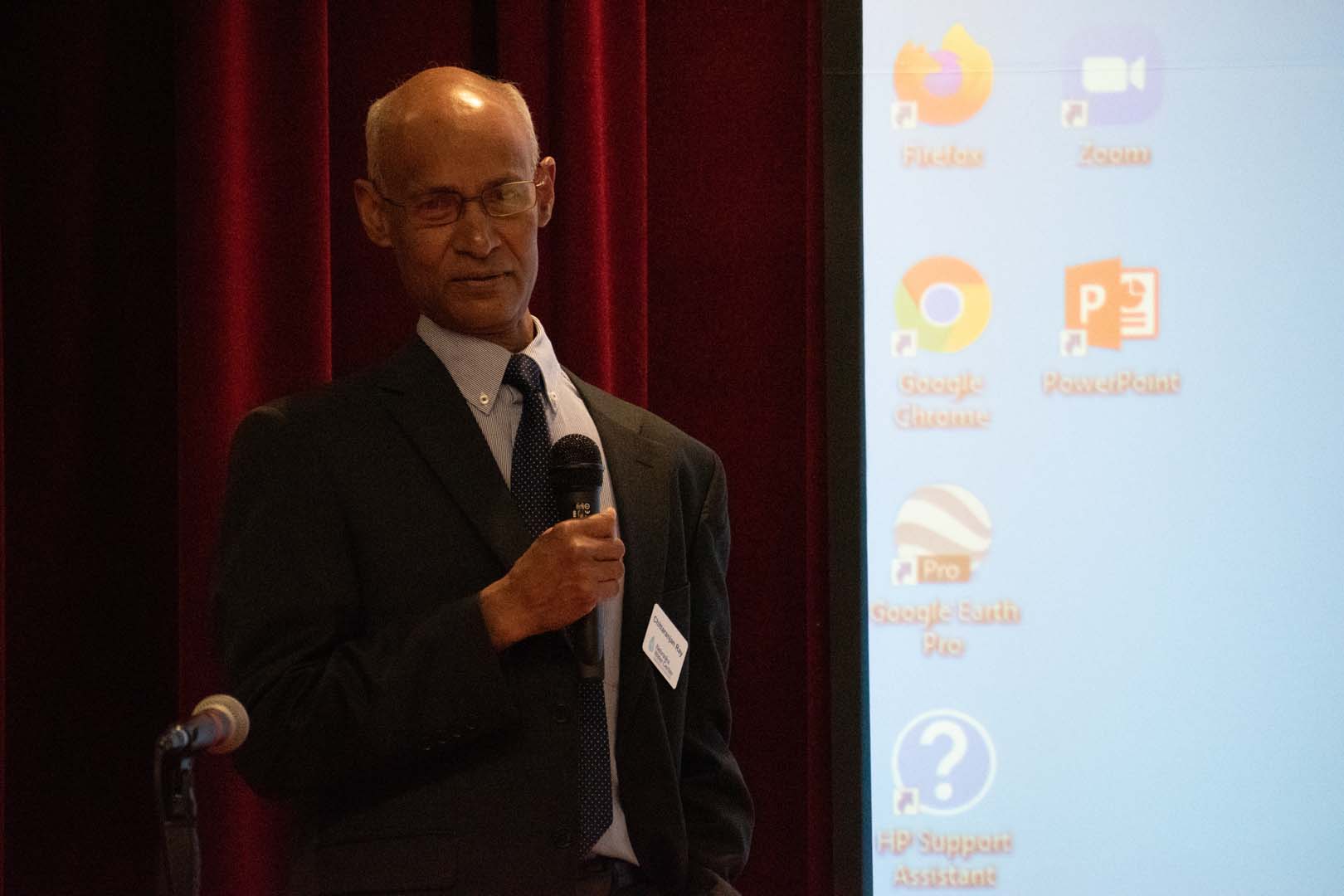 Person presenting in front of large computer screen