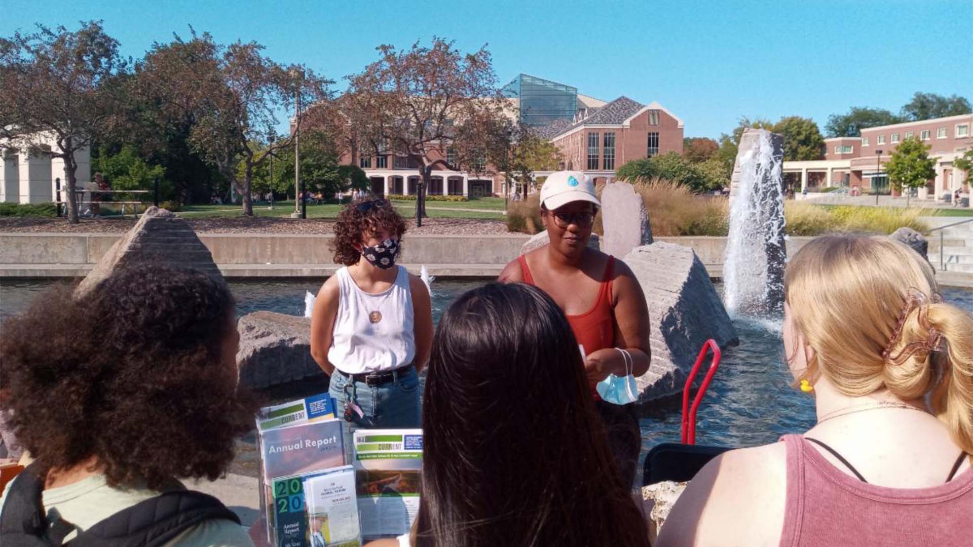 People standing outside talking around table
