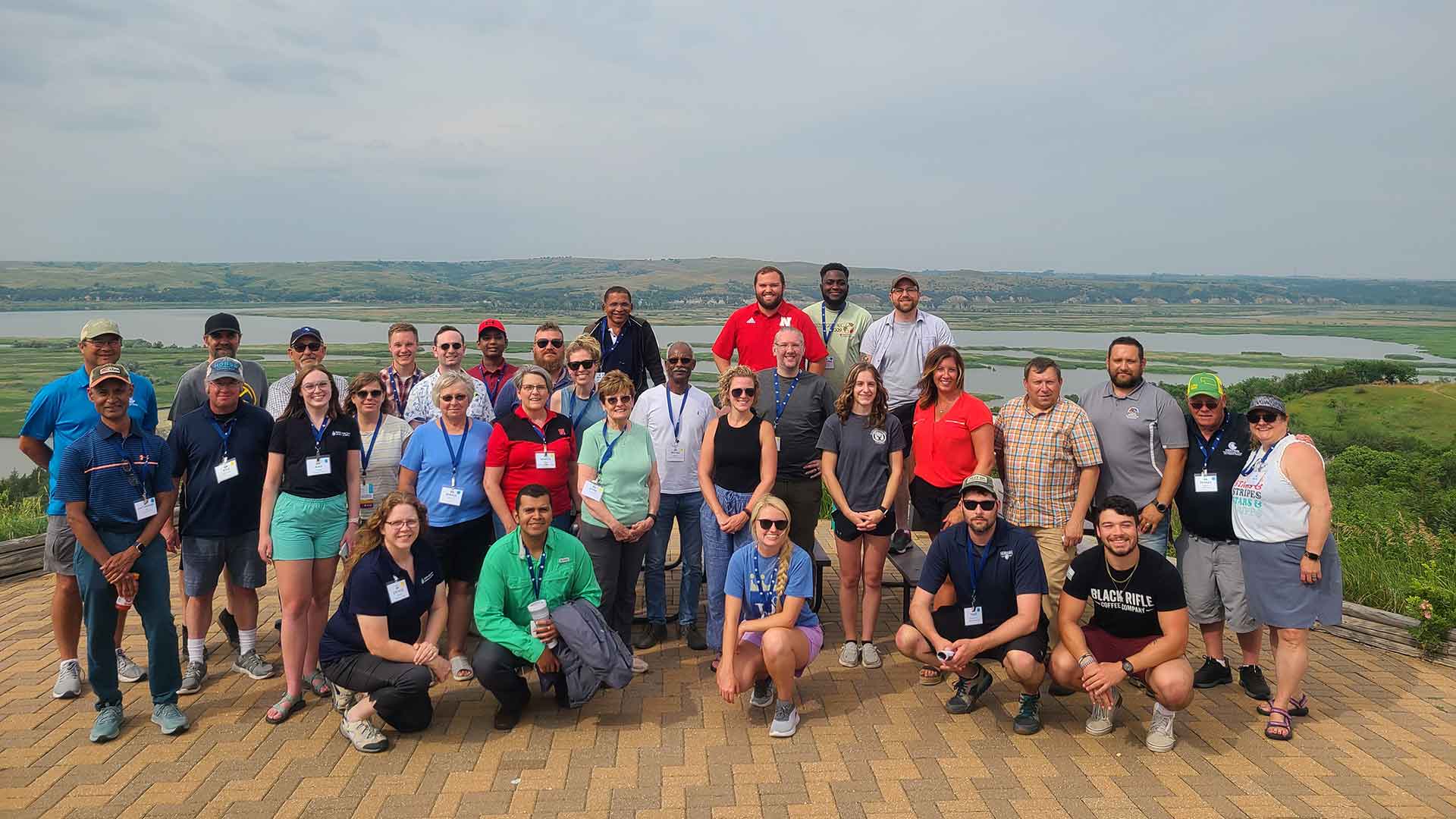 Large group standing in front of water