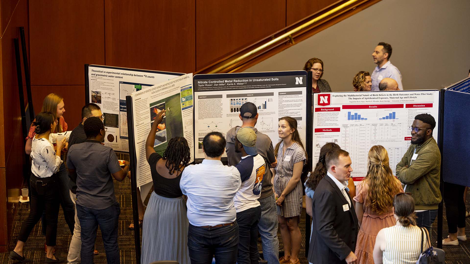 People standing in groups looking at posters